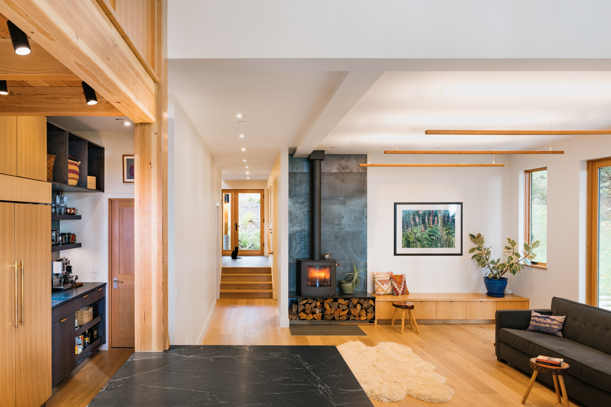 A light-filled living space wrapped in warm wood, with cozy details like a built-in window seat overlooking nature.