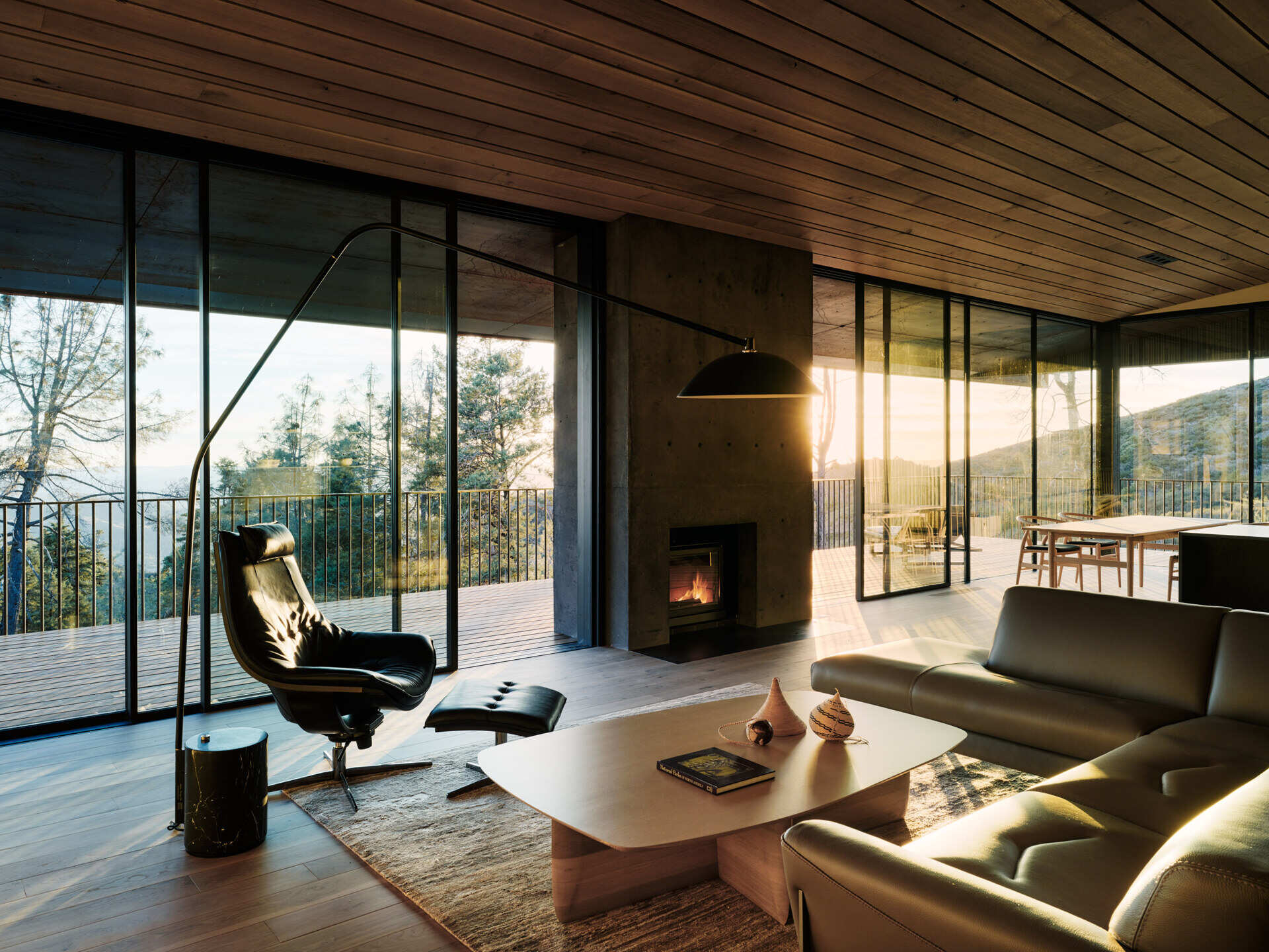 A concrete chimney anchors the living space, framing fire as both a necessity and a reminder of the surrounding environment.