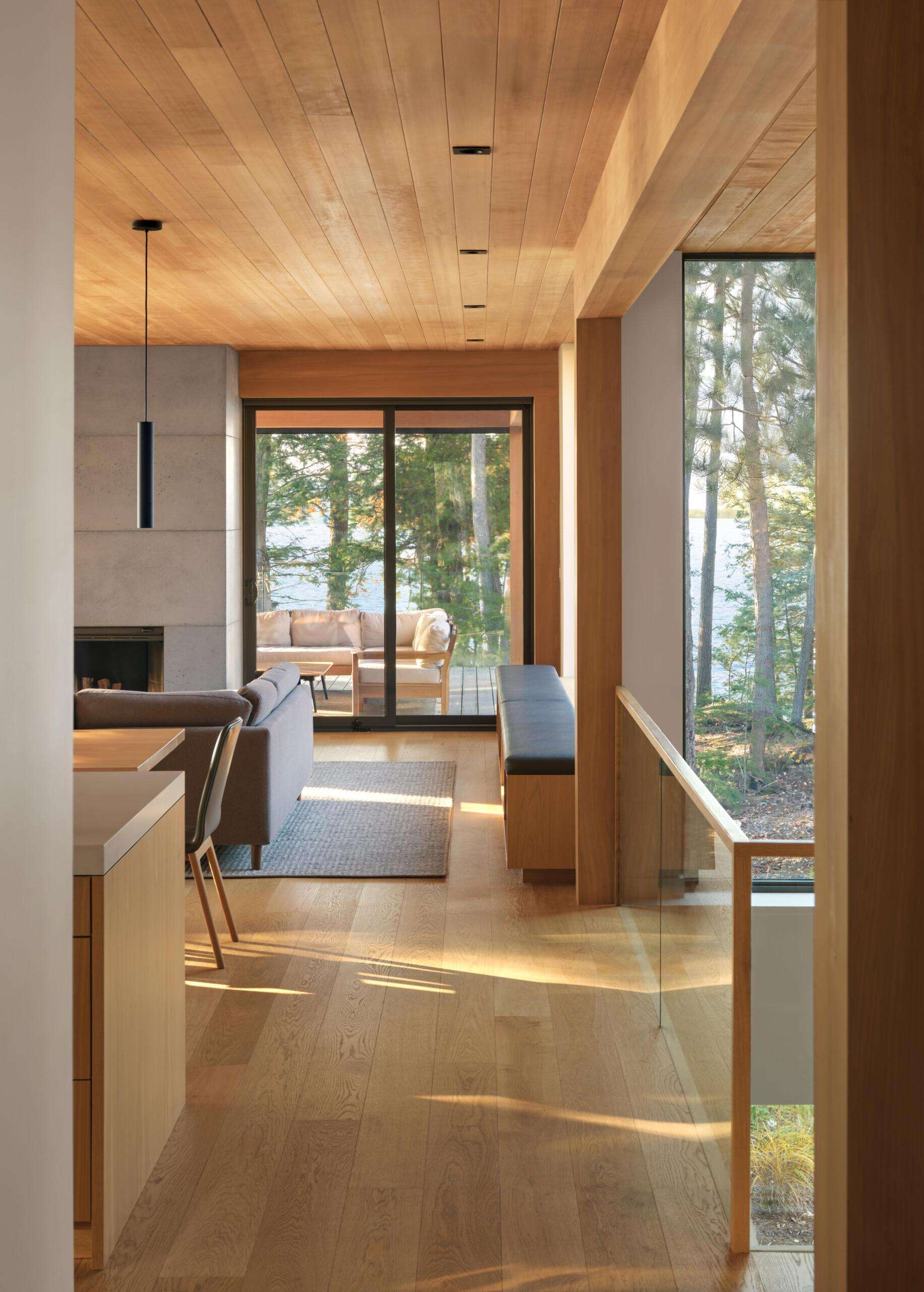 A spacious upper deck with treetop views, retractable screens, and an outdoor fireplace creates a seamless extension of the living space into the forest canopy.