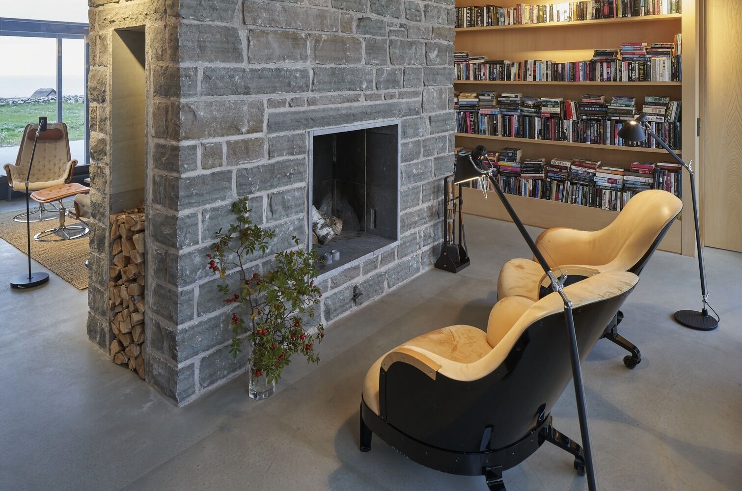 The same limestone used outside continues indoors, forming a central wall that separates the main living room from a smaller sitting area with a fireplace. This transition from exterior to interior feels seamless, with materials carrying through the entire home.