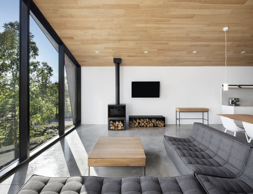 A large wall of windows at one end of the living room frames the river, filling the space with light and bringing the outdoors inside.