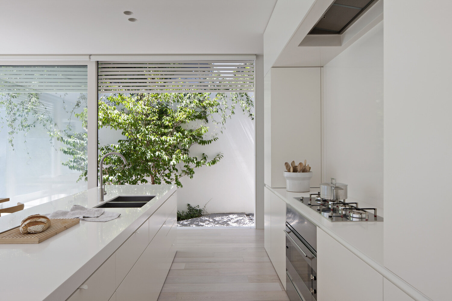 Flooded with northern light, the open plan living, dining, and kitchen space feels bright, calm, and deeply connected to the surrounding garden.