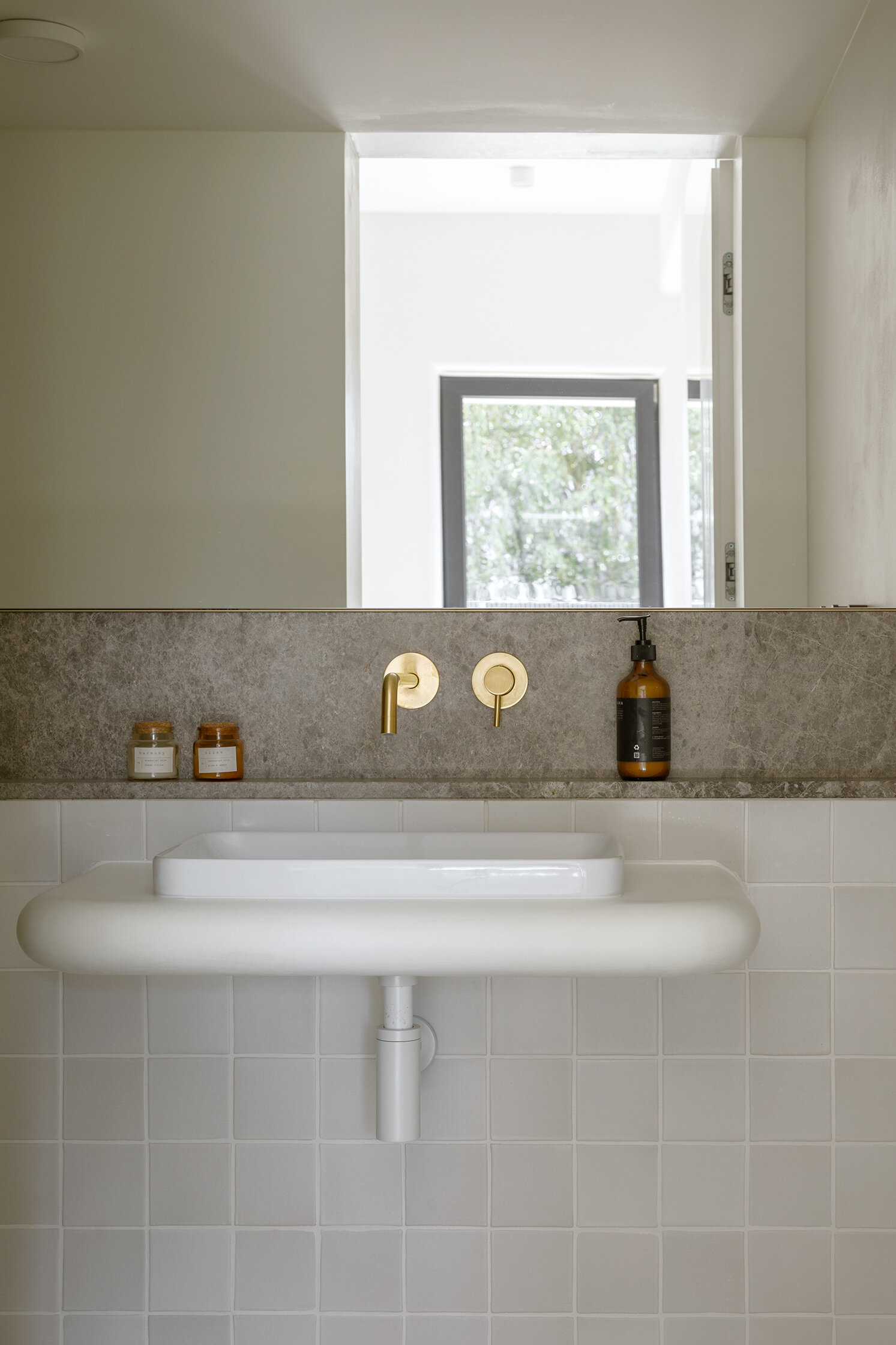 A minimal powder room where soft forms and refined finishes create a seamless extension of the home’s calm aesthetic.