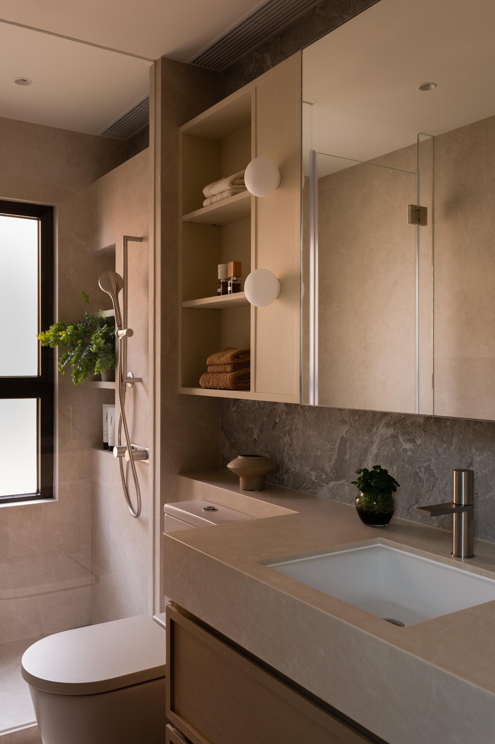 In the primary bathroom, earthy tiles and grey marble combine to create a grounded, refined space for everyday routines.