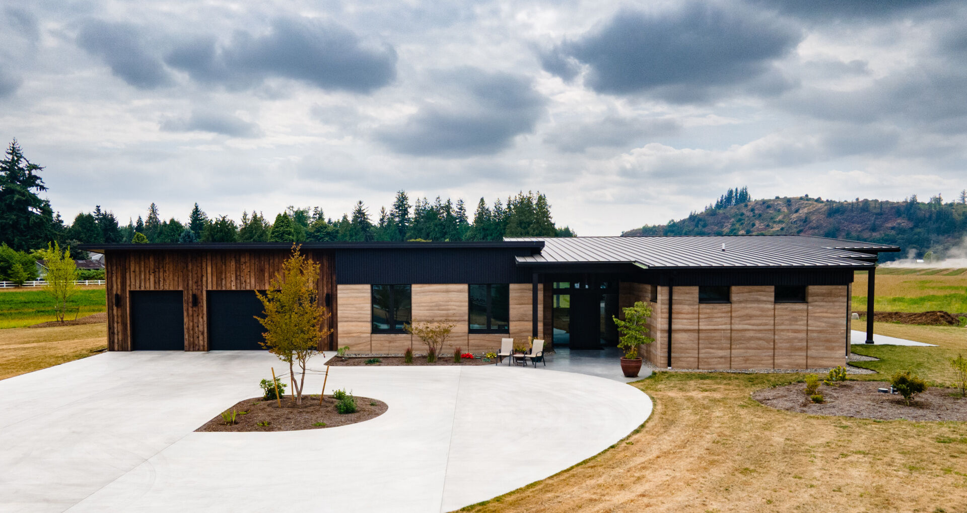 The home’s 24 inch thick walls combine two layers of rammed earth with a core of rigid insulation, creating a structural wall system that delivers durability and energy efficiency.