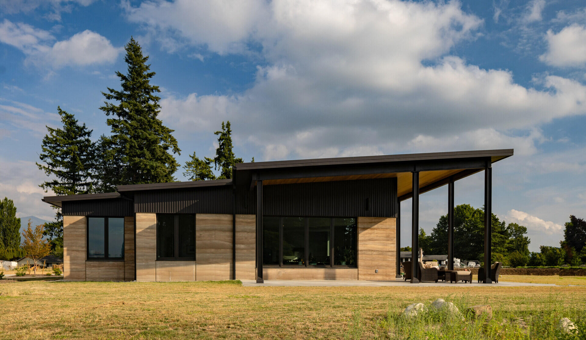The home’s 24 inch thick walls combine two layers of rammed earth with a core of rigid insulation, creating a structural wall system that delivers durability and energy efficiency.