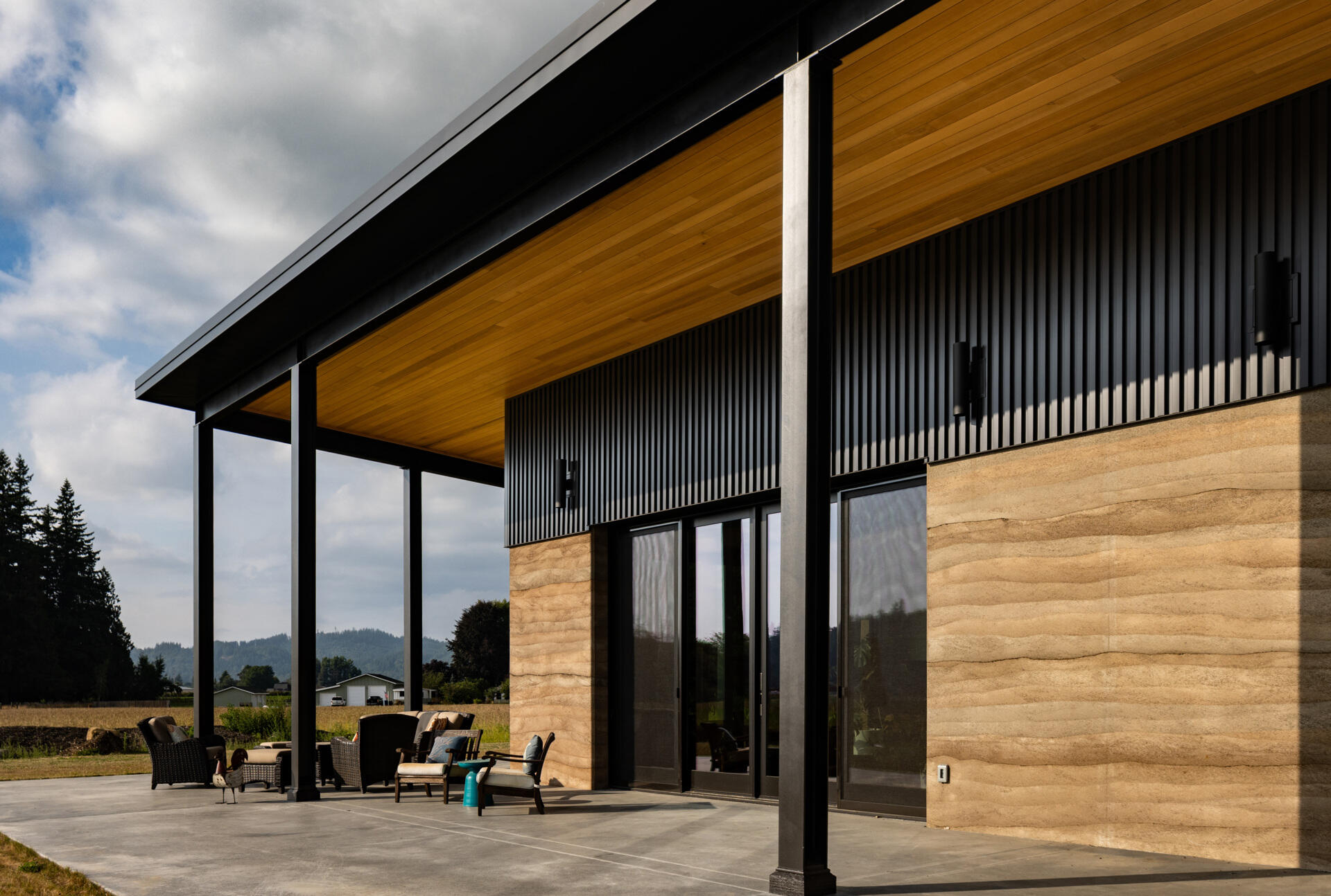 A large covered patio faces southeast, shading the home during summer while allowing winter sunlight to reach the interior for passive heating.