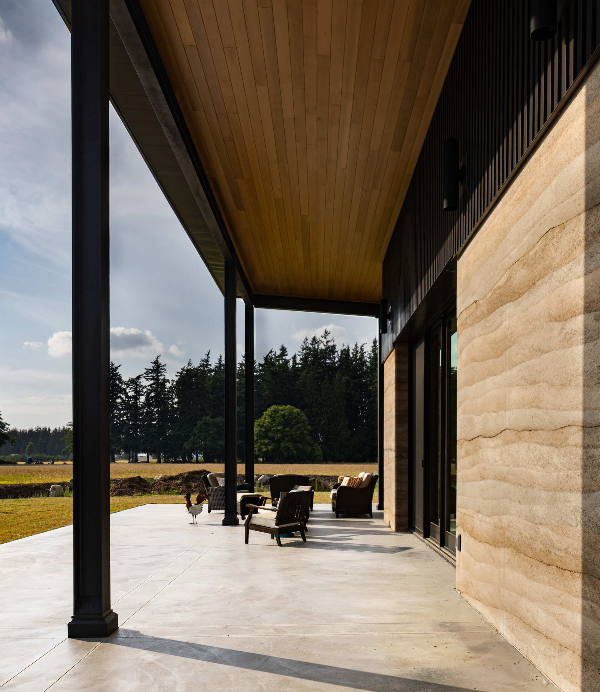 A large covered patio faces southeast, shading the home during summer while allowing winter sunlight to reach the interior for passive heating.