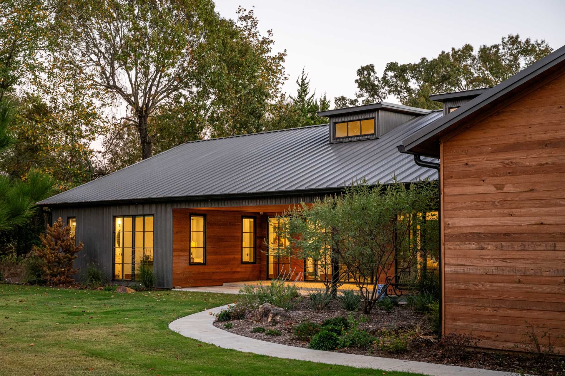 The restrained material palette of wood and metal combines rustic textures with refined modern finishes, integrating this ranch house into its East Texas context without competing with the landscape.