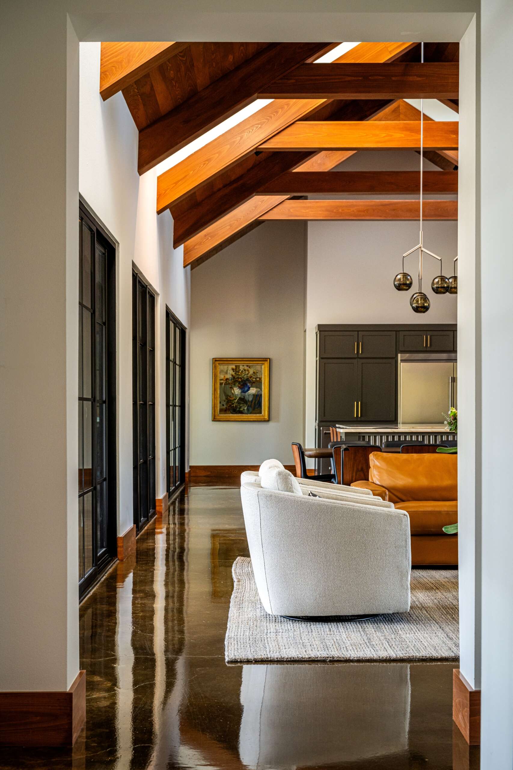 A central great room with a stone fireplace surround, accommodates dining, socializing, and circulation.