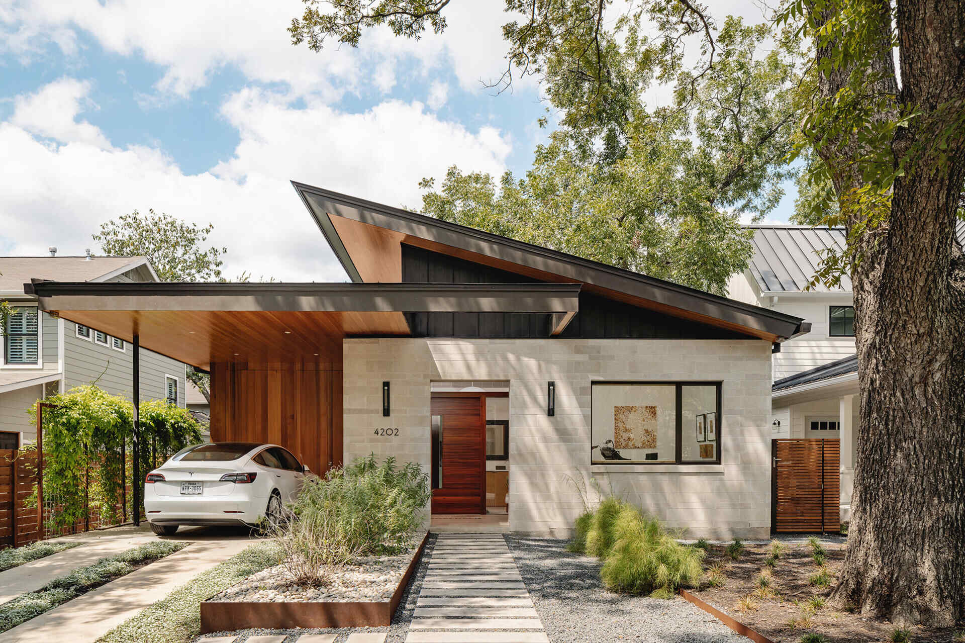A modern Austin home with a sharp roofline pairs limestone walls with cedar and hemlock details, creating a warm yet precise exterior that balances natural materials with clean architectural lines.