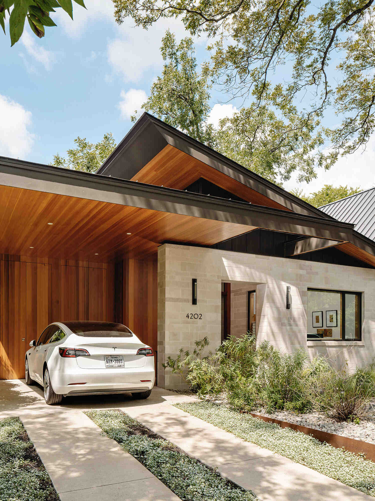 A modern Austin home with a sharp roofline pairs limestone walls with cedar and hemlock details, creating a warm yet precise exterior that balances natural materials with clean architectural lines.