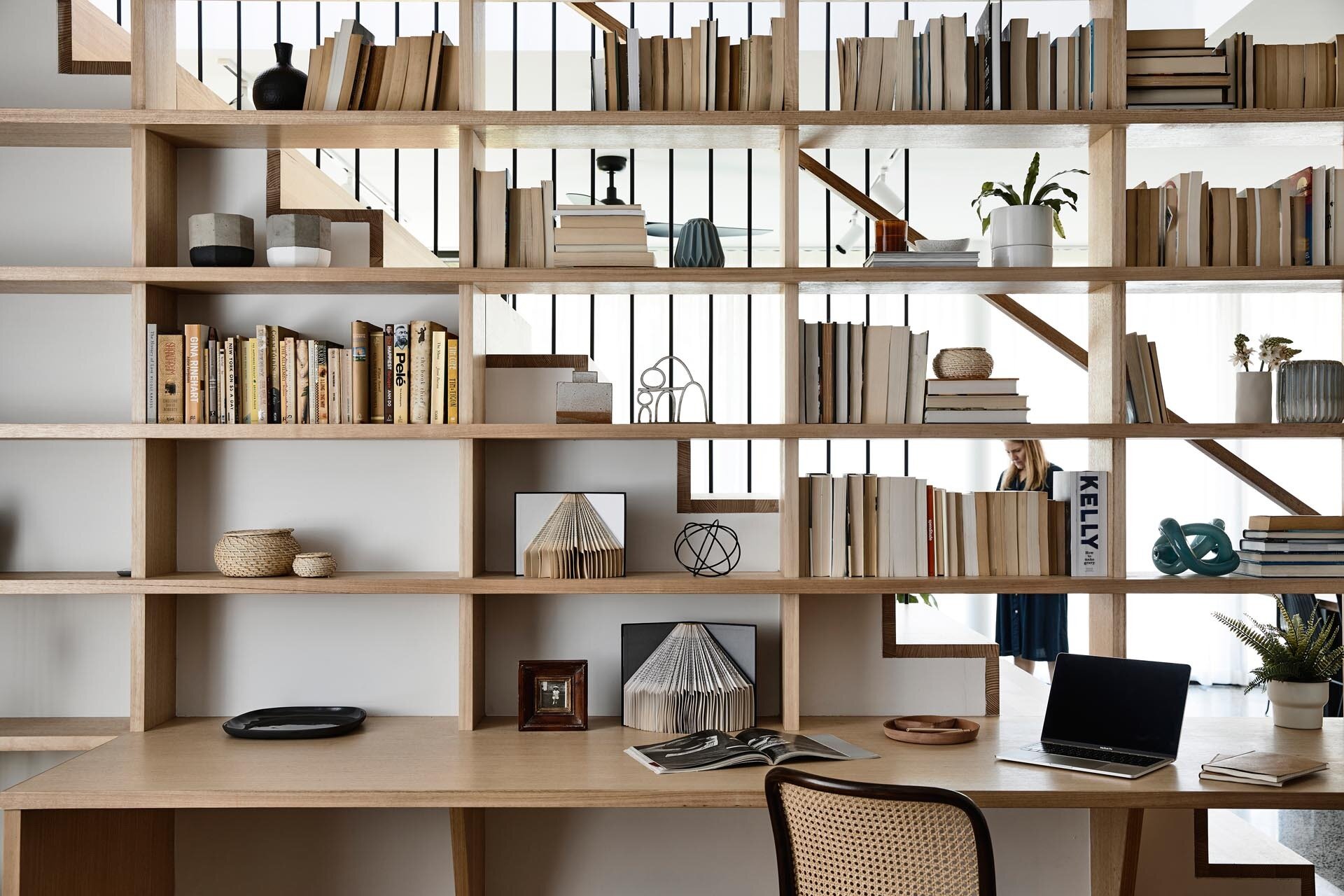 Double-sided bookshelf with desk integrates the home office into family life.