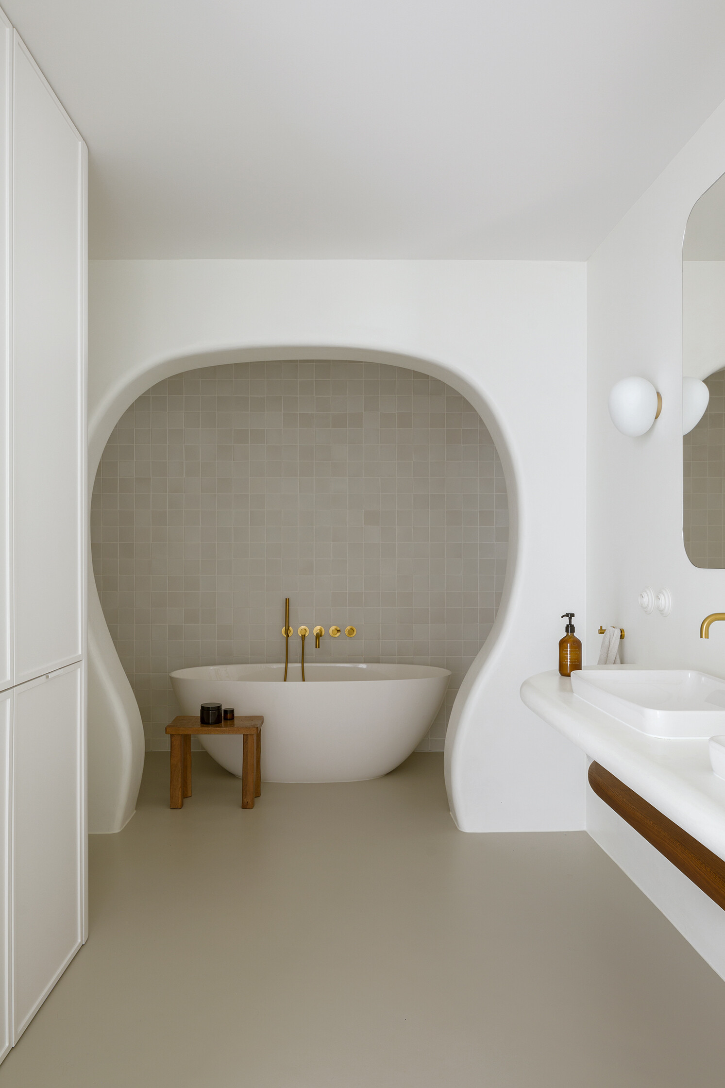 A family bathroom with a bathtub and shower alcove, designed as sculptural niches that add depth and softness.