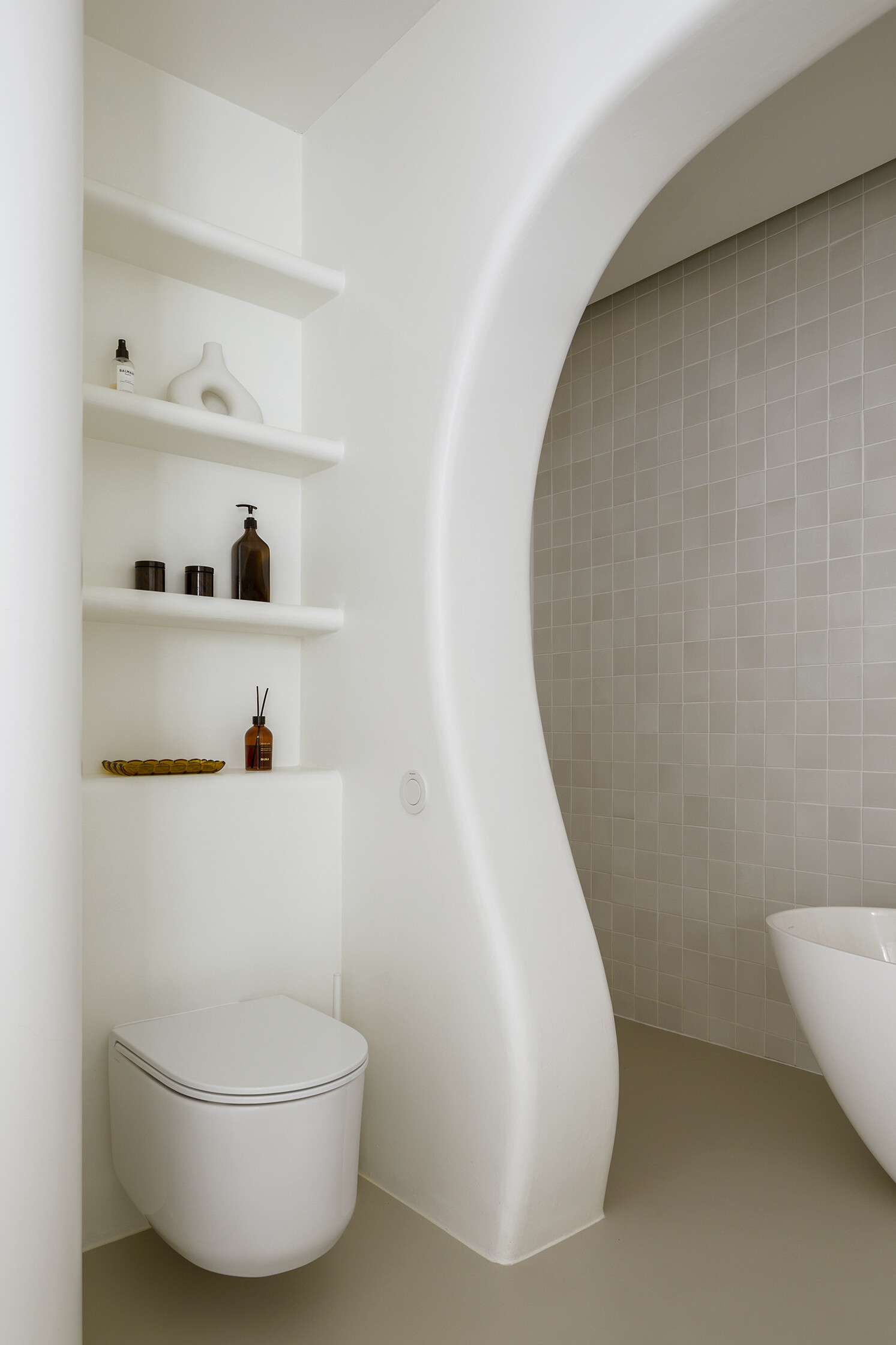 A family bathroom with a bathtub and shower alcove, designed as sculptural niches that add depth and softness.