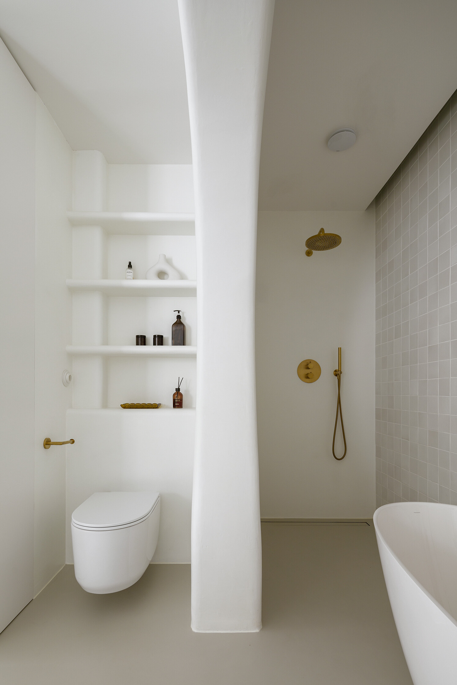 A family bathroom with a bathtub and shower alcove, designed as sculptural niches that add depth and softness.