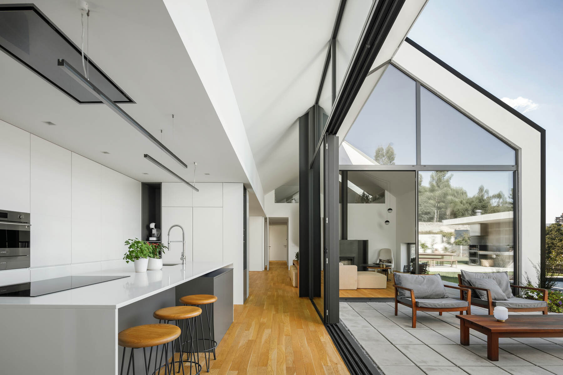 A minimalist kitchen pairs white cabinetry with a gray island and built-in wine storage for a clean and practical design.