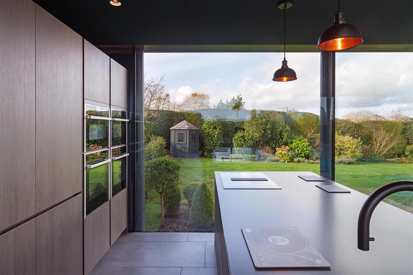 Light wood cabinetry and a dark countertop create a clean, modern kitchen with a warm, balanced feel.