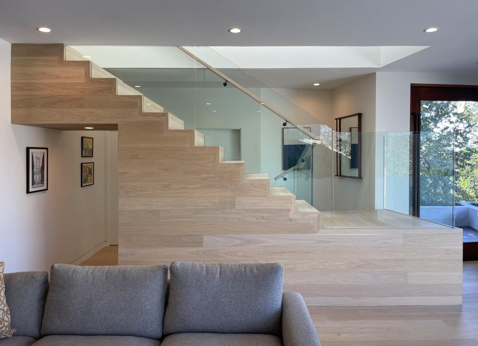 A central wood staircase ties the home together vertically. Running beneath a skylight, it brings light into the core of the house. As you move up or down, the changing light adds to the experience.