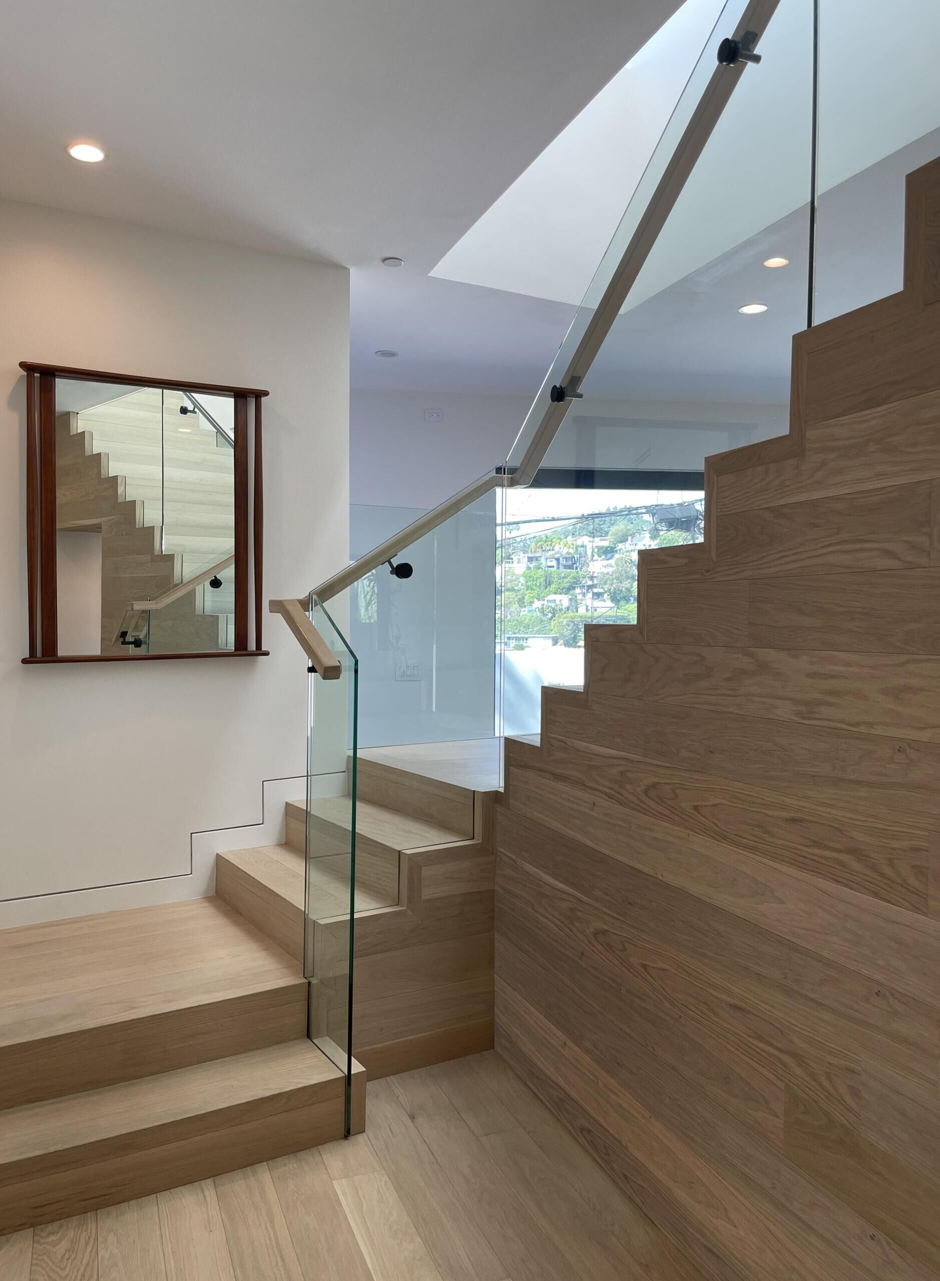 A central wood staircase ties the home together vertically. Running beneath a skylight, it brings light into the core of the house. As you move up or down, the changing light adds to the experience.
