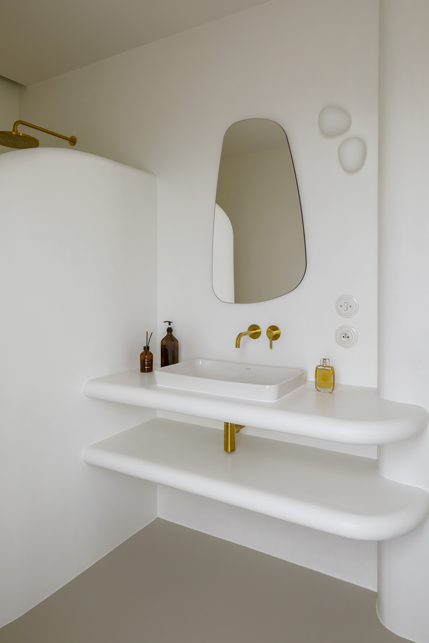 A spa-like ensuite with a curved walk-in shower and seamless surfaces that soften light and space.