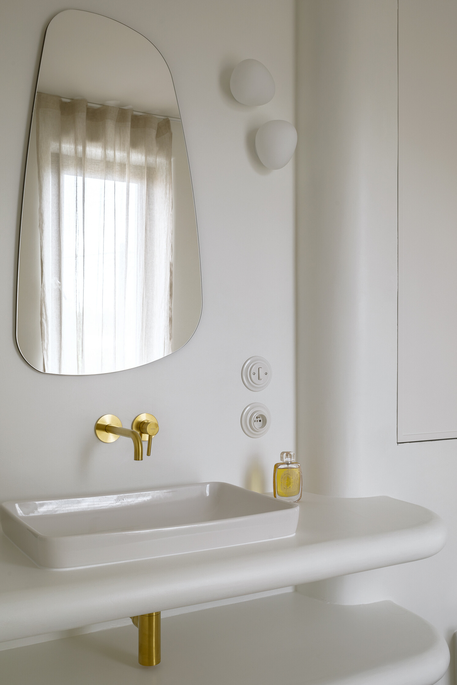A spa-like ensuite with a curved walk-in shower and seamless surfaces that soften light and space.