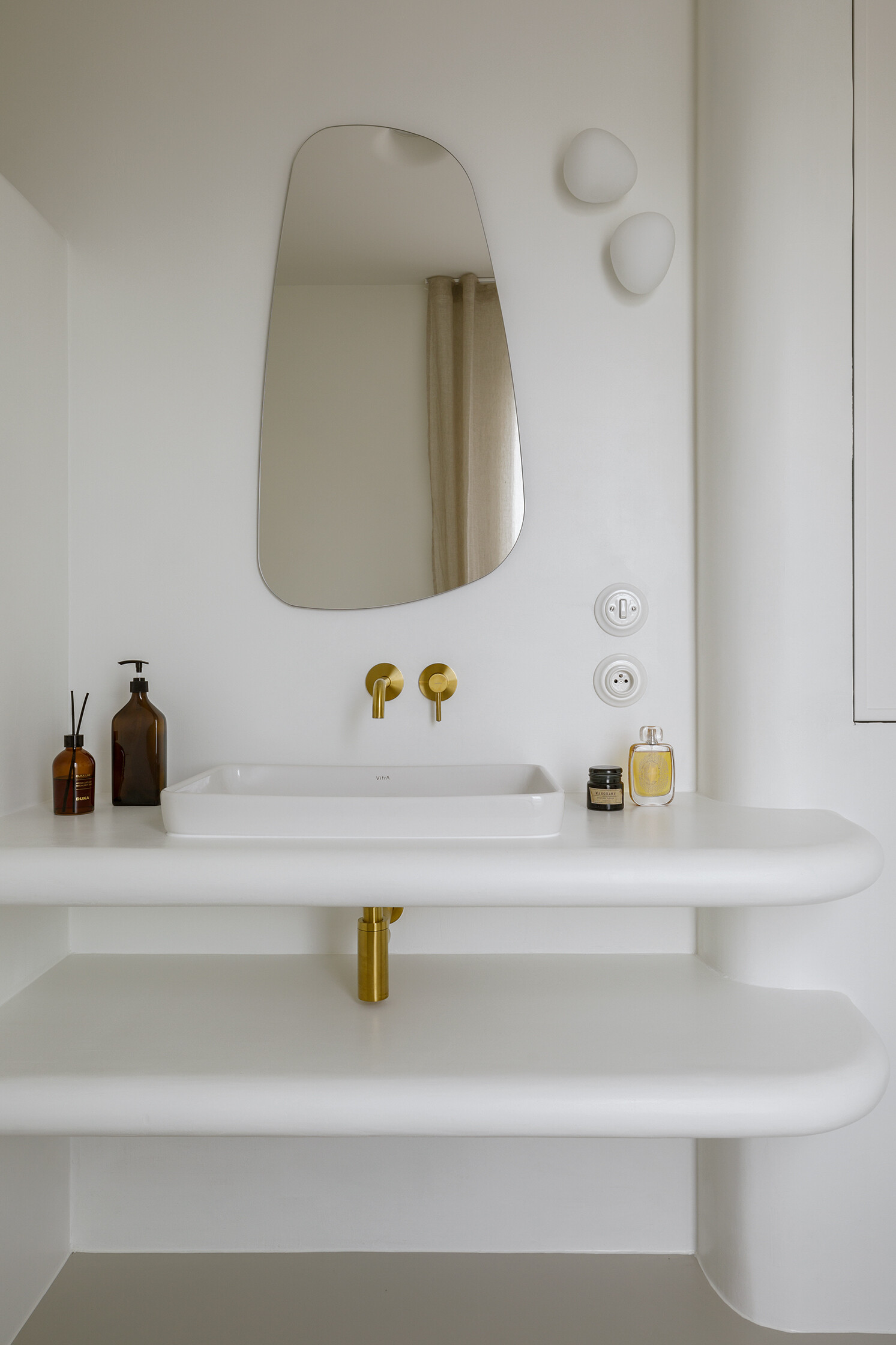 A spa-like ensuite with a curved walk-in shower and seamless surfaces that soften light and space.