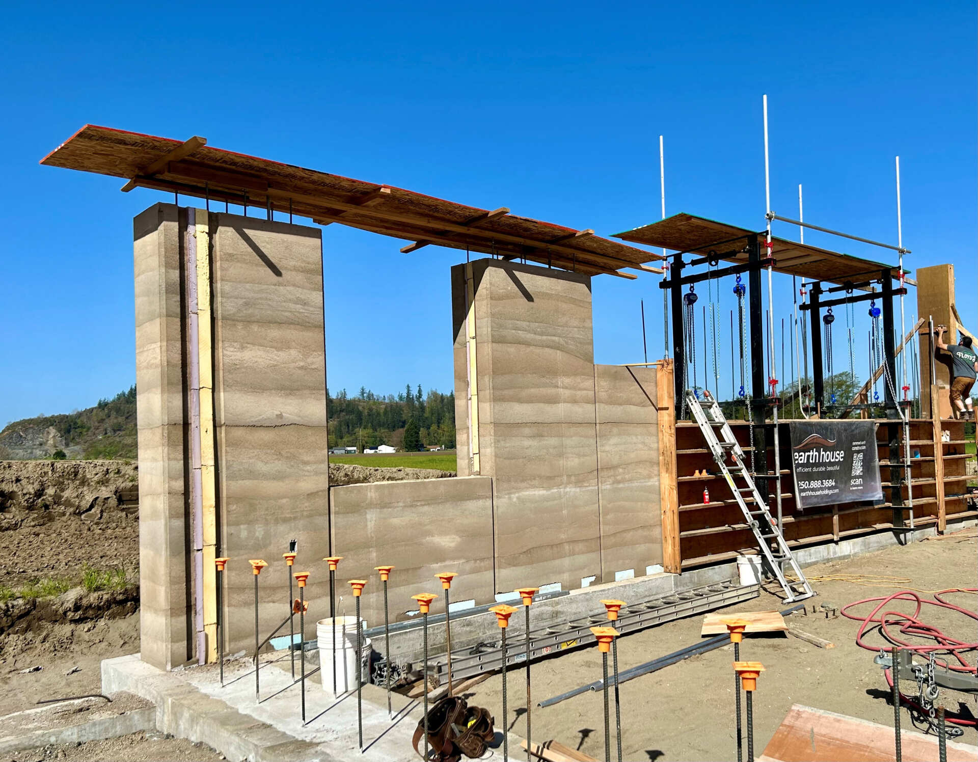 The rammed earth walls were formed by compacting layers of local soil, sand, and gravel inside specialized formwork, creating the distinctive horizontal bands seen throughout the house.