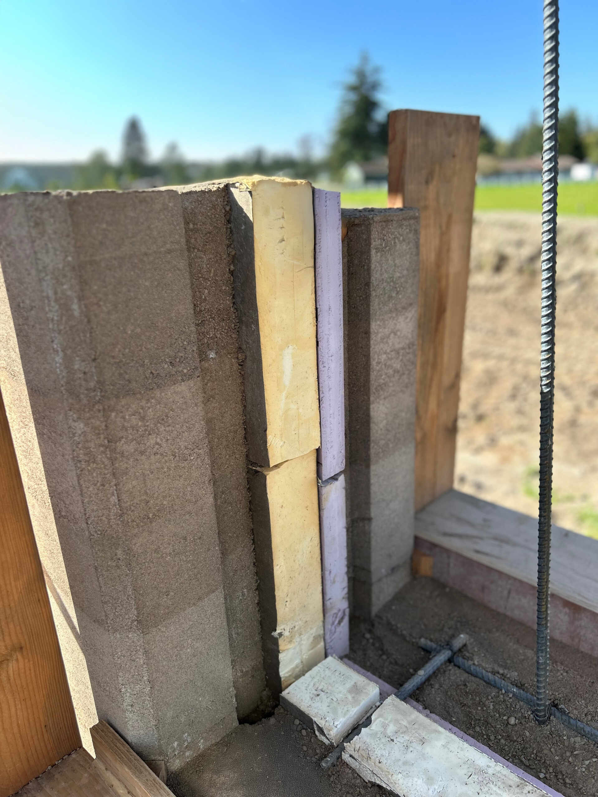 The rammed earth walls were formed by compacting layers of local soil, sand, and gravel inside specialized formwork, creating the distinctive horizontal bands seen throughout the house.