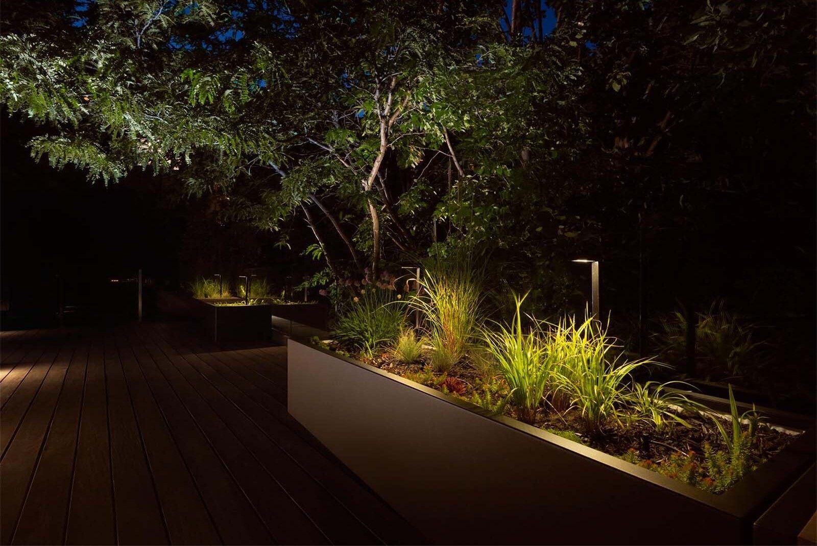 As night falls, this rooftop garden shifts into a warm, intimate setting perfect for slow evenings above the city.
