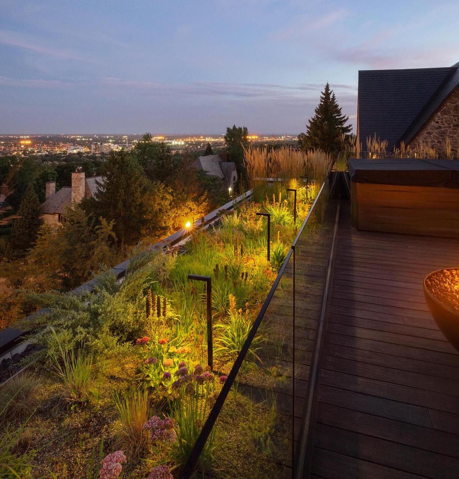 As night falls, this rooftop garden shifts into a warm, intimate setting perfect for slow evenings above the city.