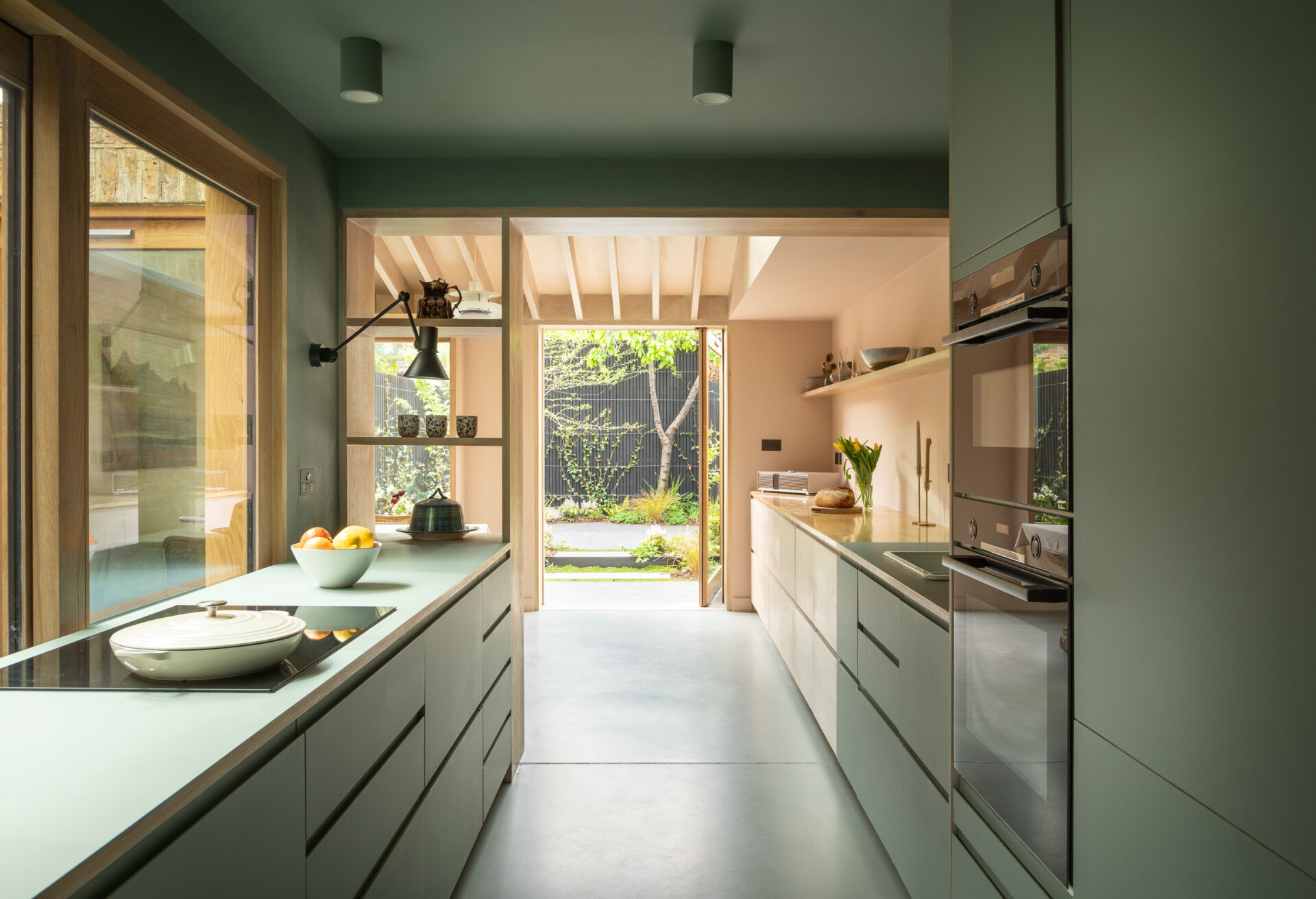 Una extensión inspirada en una cabaña de Turner Architects transforma el borde de un pequeño jardín urbano en un espacio de salón y cocina sólido y basado en materiales.