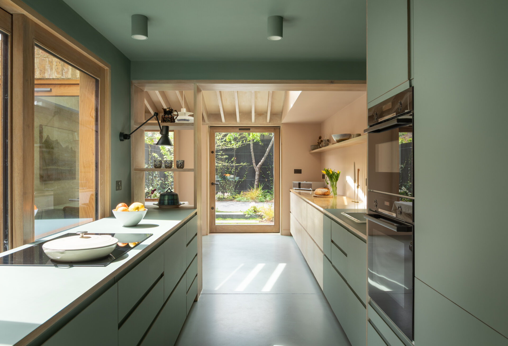 Una extensión inspirada en una cabaña de Turner Architects transforma el borde de un pequeño jardín urbano en un espacio de salón y cocina sólido y basado en materiales.