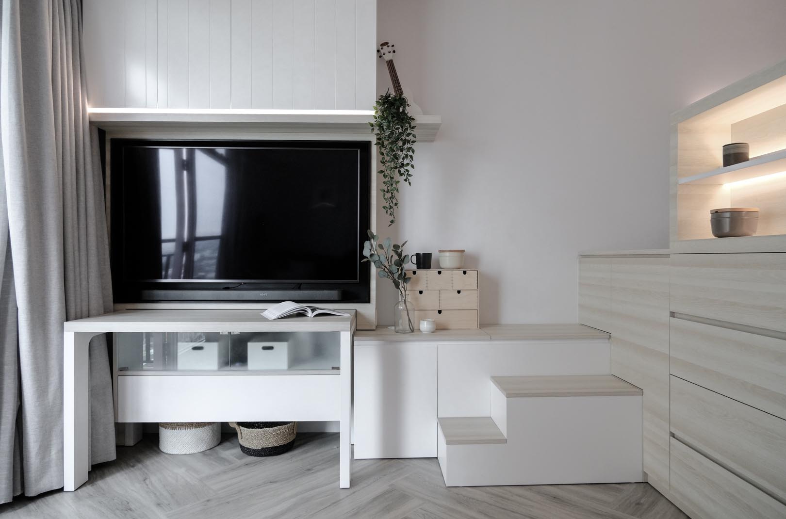A multi-functional setup where a dining table doubles as a desk and built-in cabinets become stairs, perfect for small apartment living.