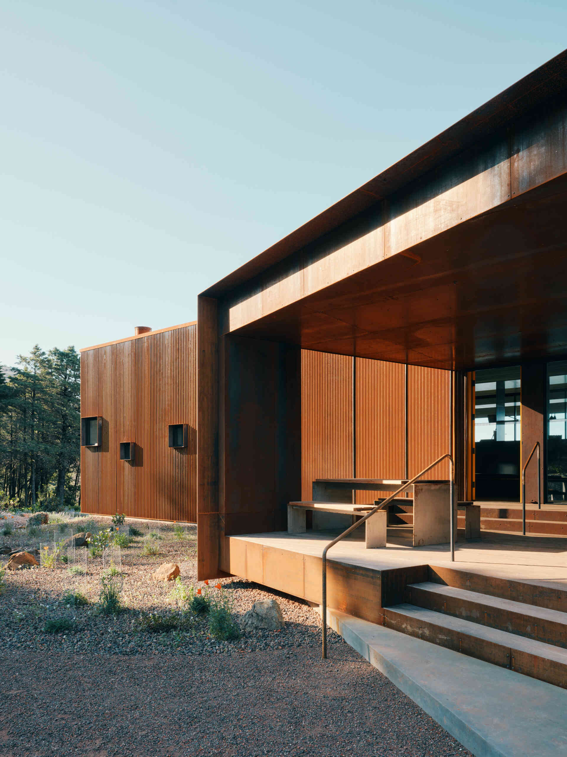 A corten steel exterior, ember screens, and integrated sprinklers work together to protect this home while keeping maintenance low.