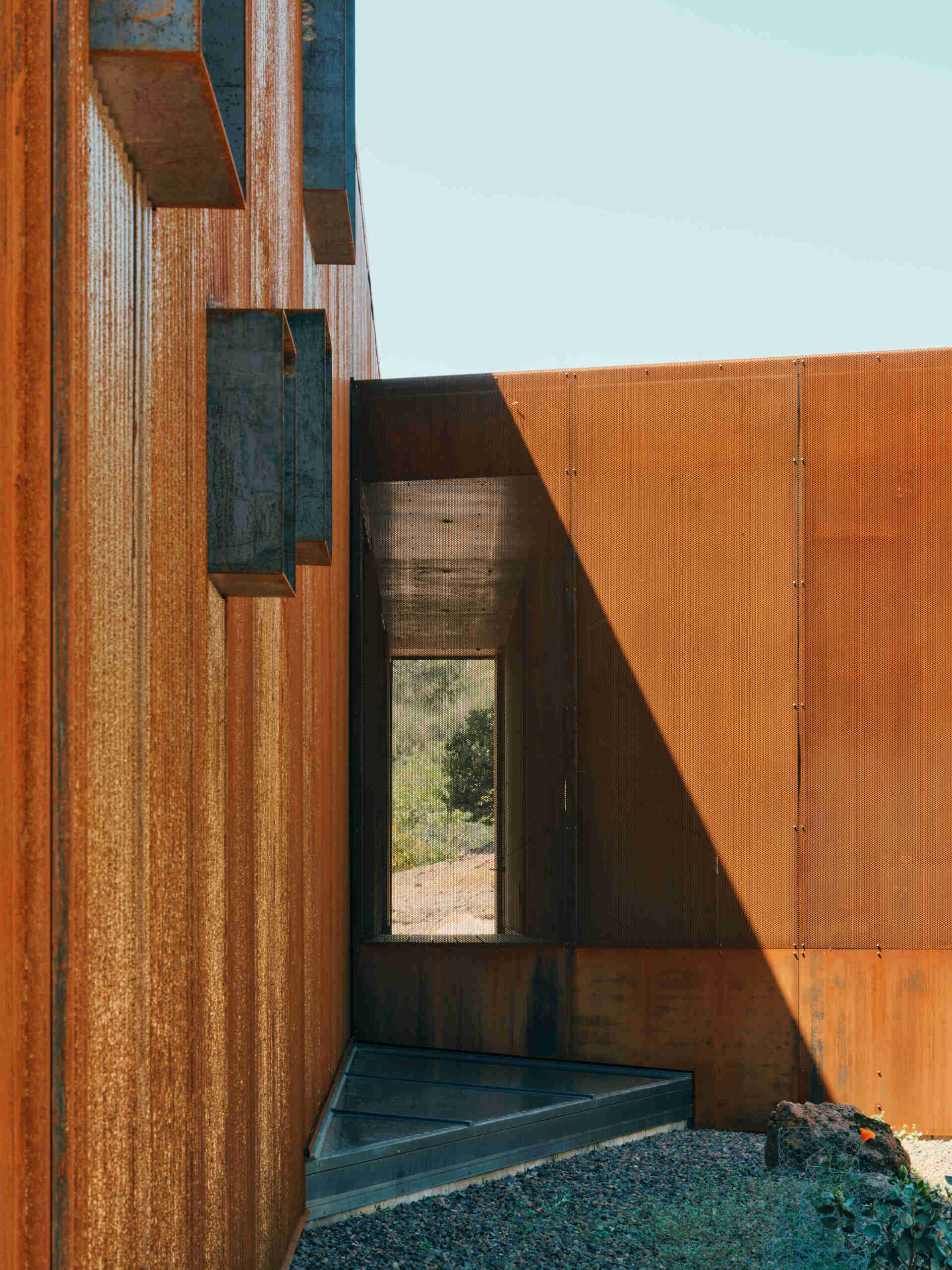 A corten steel exterior, ember screens, and integrated sprinklers work together to protect this home while keeping maintenance low.