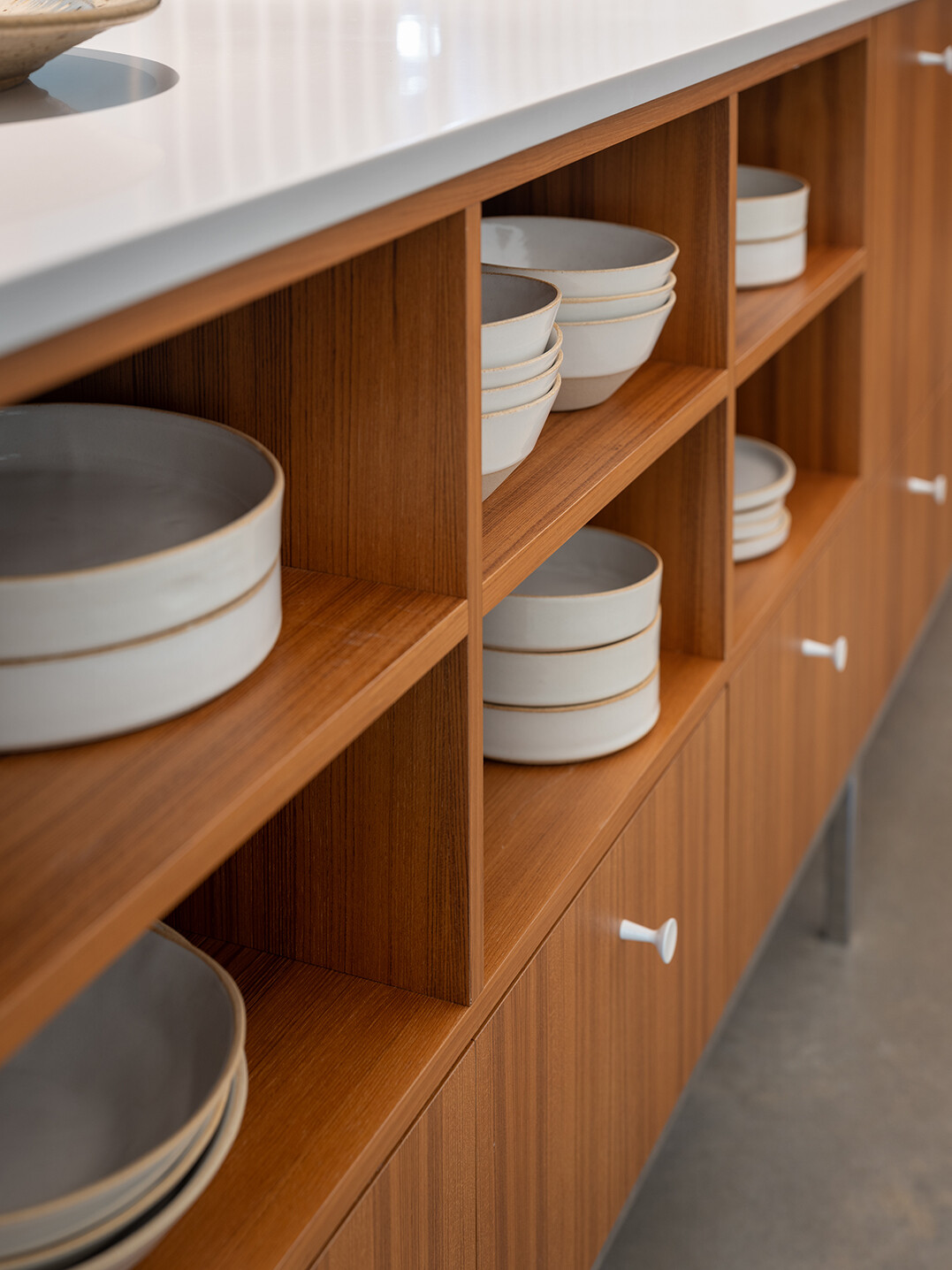 In this mid-century modern inspired kitchen, clean lines and a furniture-like design keep the space open while still providing full functionality.