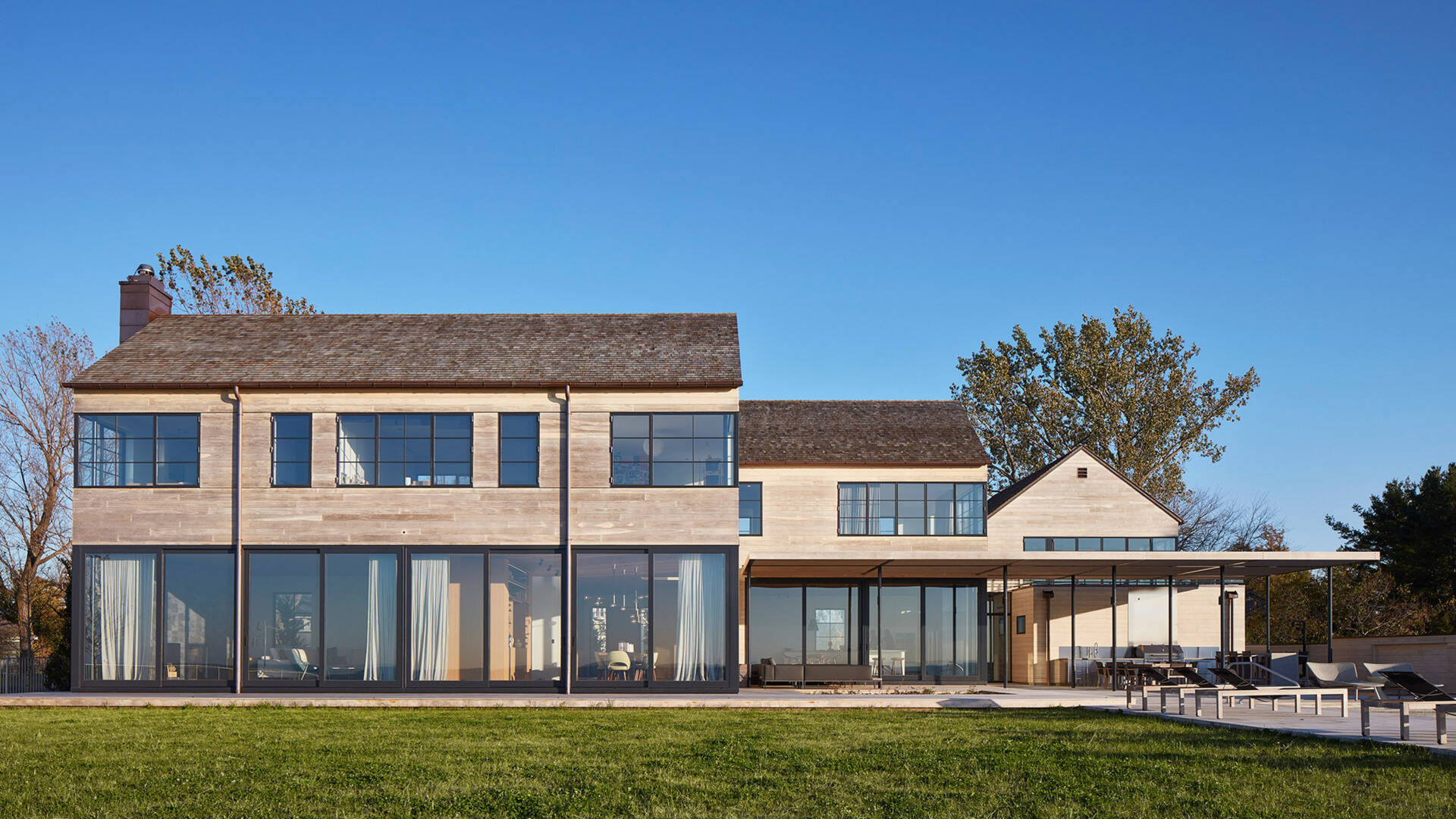 This modern house features Accoya wood siding and cedar shingles that create a durable, weather-ready exterior designed for life by the lake.