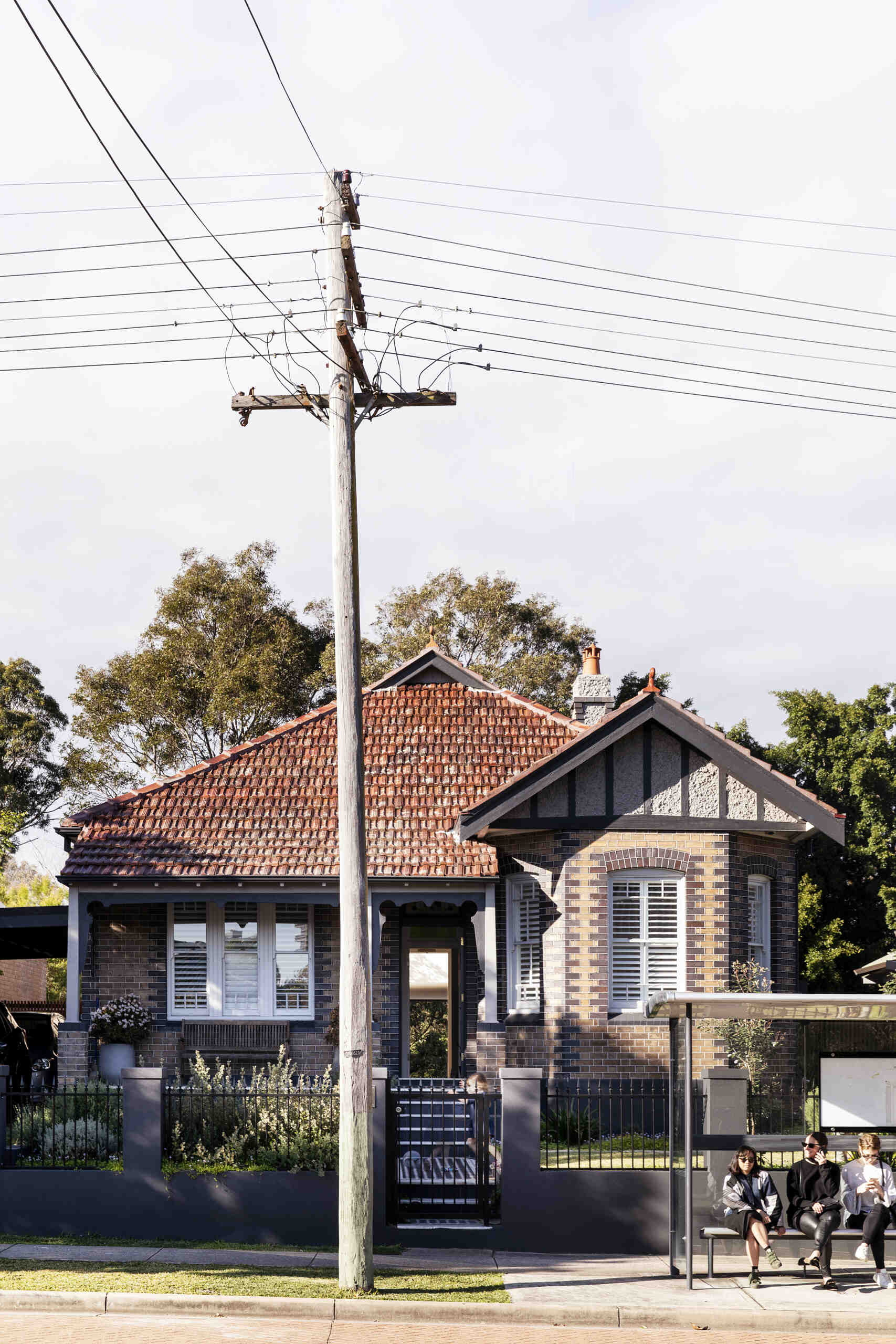 A restored Federation home keeps its original brick façade and porch, hiding a modern transformation behind a classic street presence.