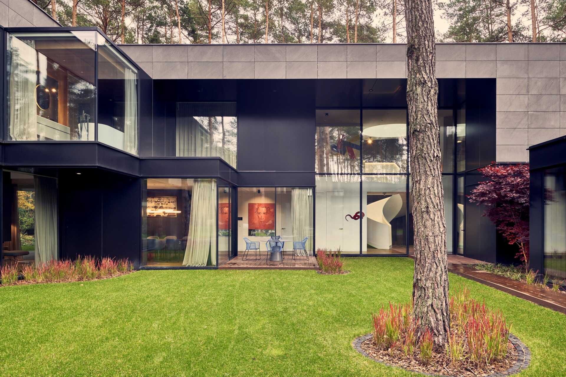 Inspired by the idea of a tree trunk, the home features carved-out spaces and glazed alcoves that create layered views throughout.