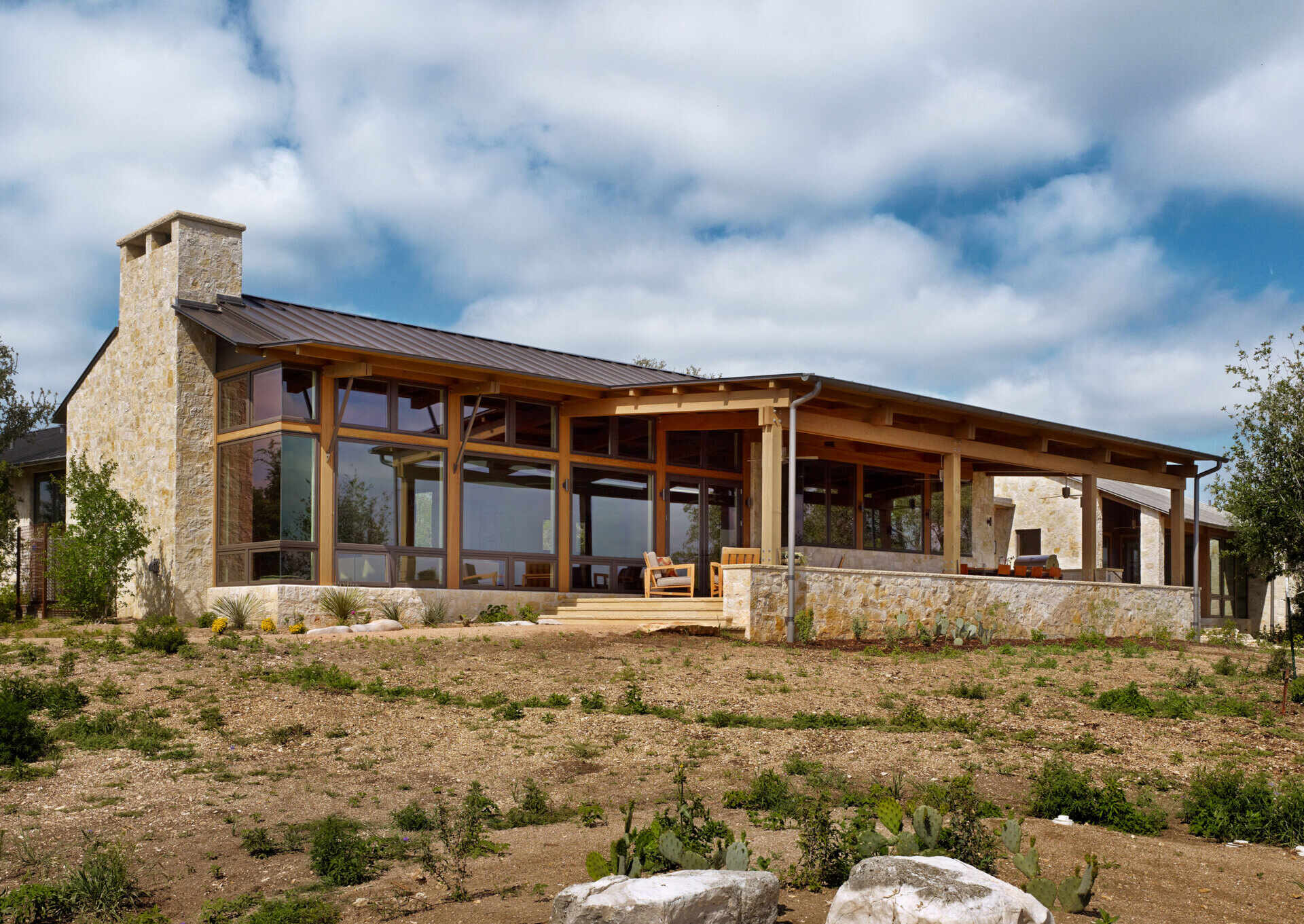 Limestone walls and a metal roof create a bold and cohesive material palette across this Texas ranch home.