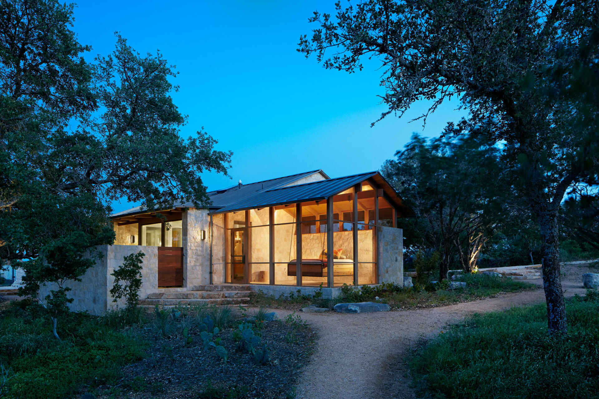 Limestone walls and a metal roof create a bold and cohesive material palette across this Texas ranch home.