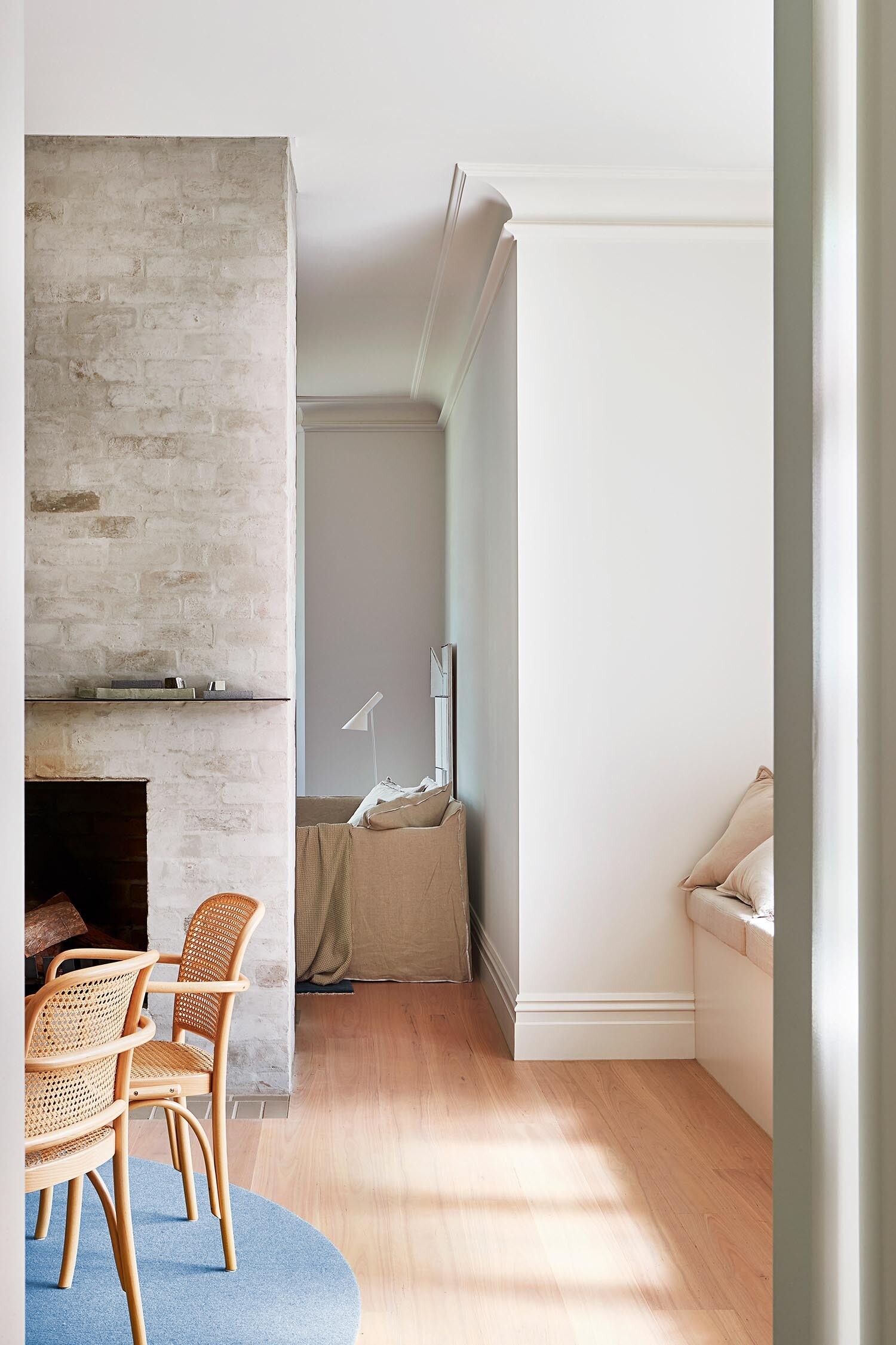 A cozy dining nook with a built-in bench and stained glass window that reflects the home’s original design features.