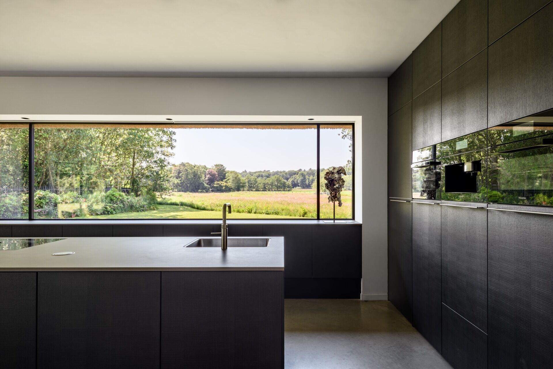 Una cocina limpia y moderna se integra con el espacio habitable, combinando funcionalidad con un diseño simple y ordenado.