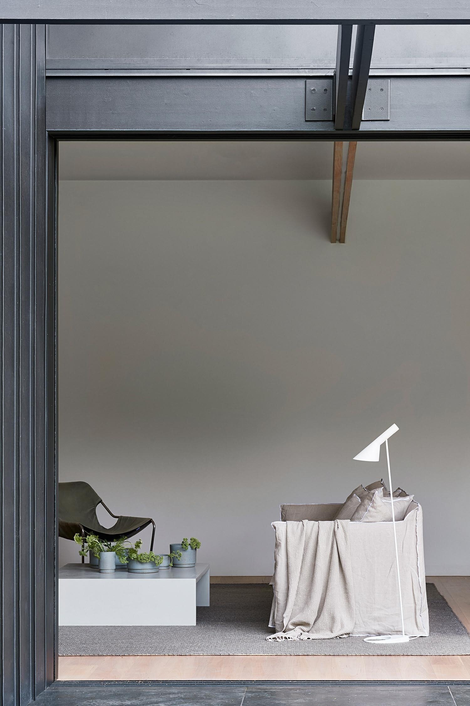 A minimalist living room centered around a fireplace, combining warmth with simple, clean design.