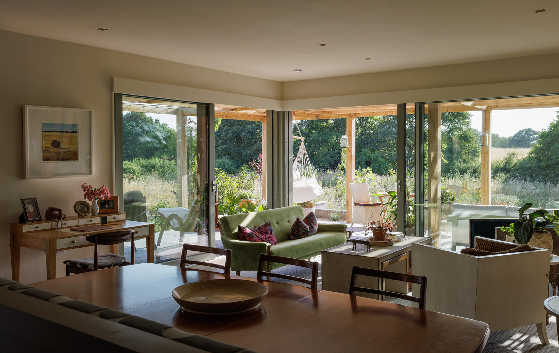 In the living room, large openings frame views of the garden, while the simple structure allows the space to feel both expansive and easy to use.