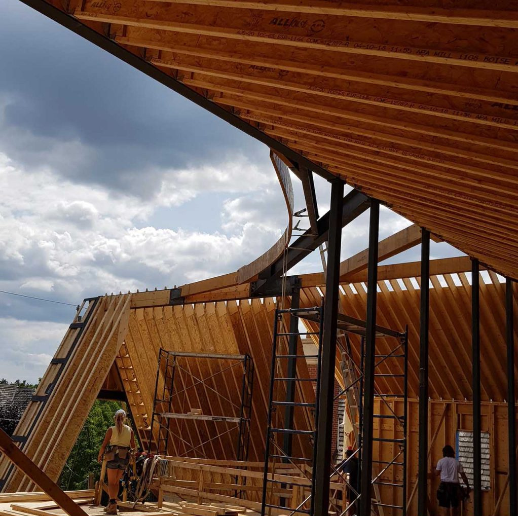 A behind-the-scenes look at how steel and timber come together to form this complex curved roof.