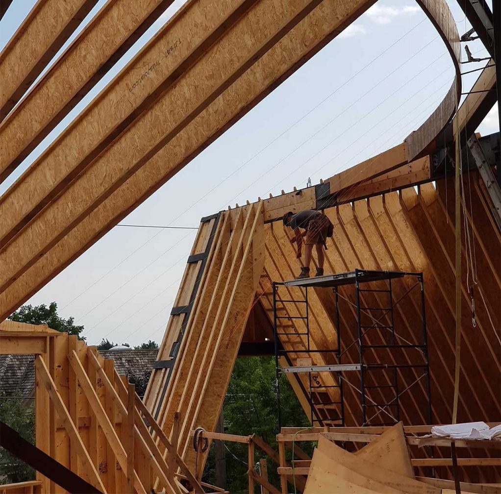 A behind-the-scenes look at how steel and timber come together to form this complex curved roof.
