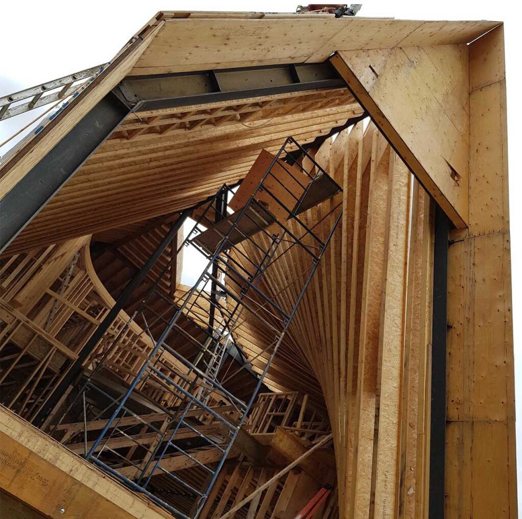 A behind-the-scenes look at how steel and timber come together to form this complex curved roof.