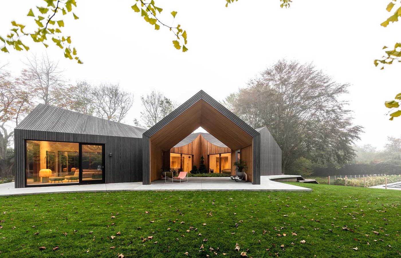 Deep gray Accoya wood cladding gives this modern home a bold exterior, with textured slats that highlight its sculptural roofline.